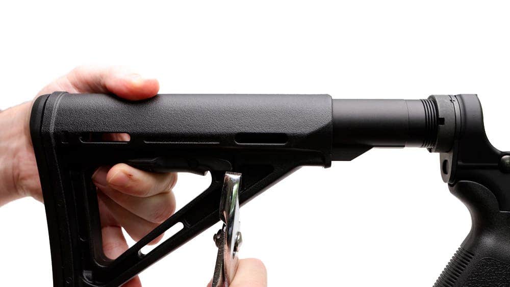 Using pliers to depress lever in middle of stock